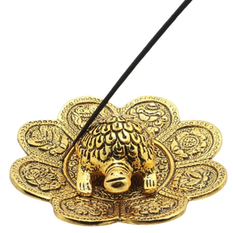incense stick in a gold turtle incense burner