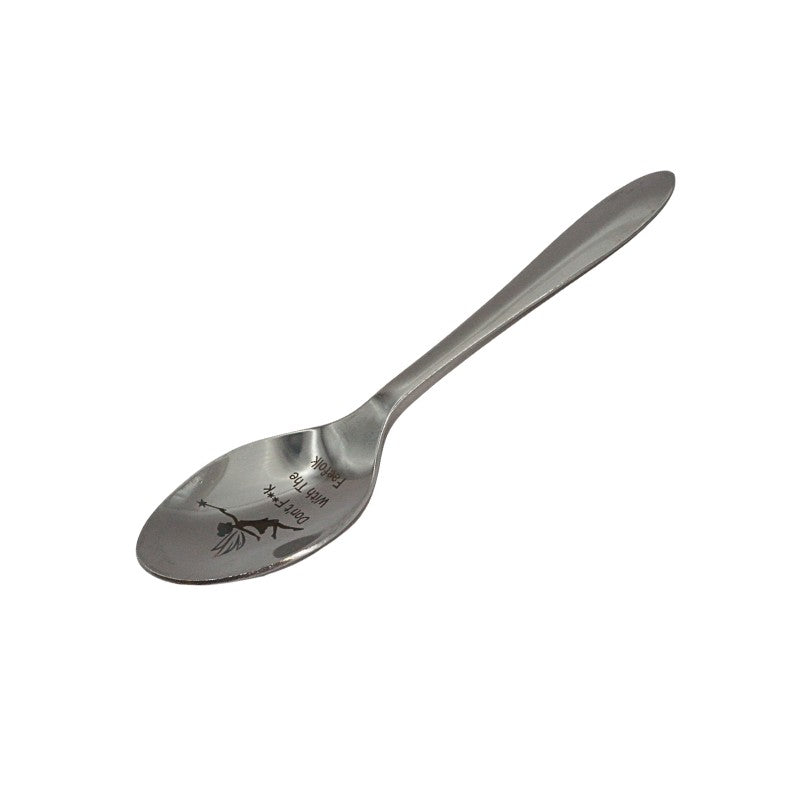 Stainless steel spoon with engraved design on a white background