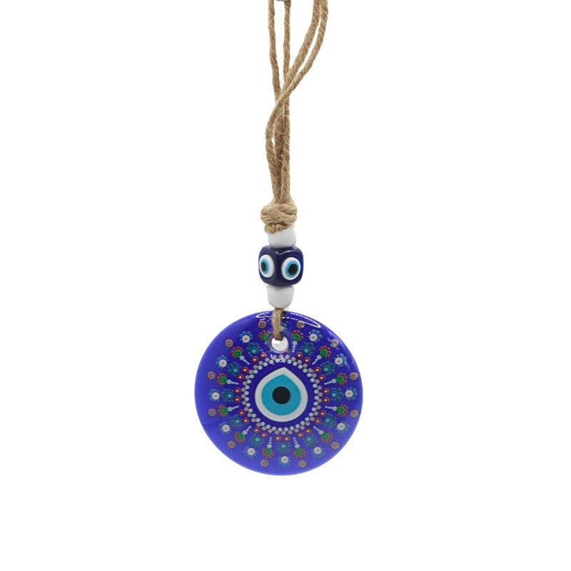 wall hanging with a blue evil eye pendant on a white background