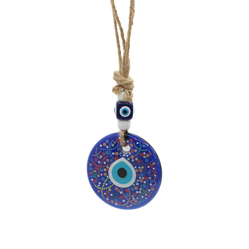 wall hanging with a blue evil eye pendant on a white background