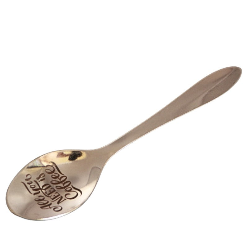 stainless steel teaspoon with "all you need is coffee" engraved in the dish