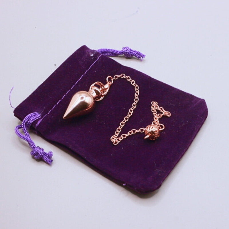rose gold pendulum on purple velvet bag