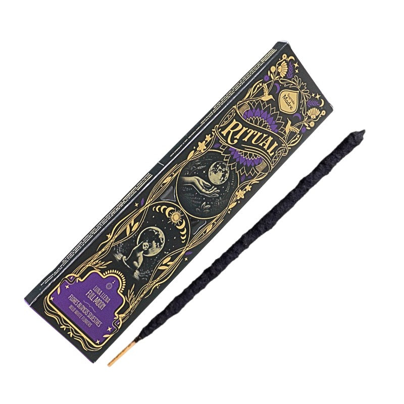 A black ritual incense stick with a gold tip lies diagonally next to its ornate black and gold packaging box featuring purple accents, set against a plain white background.