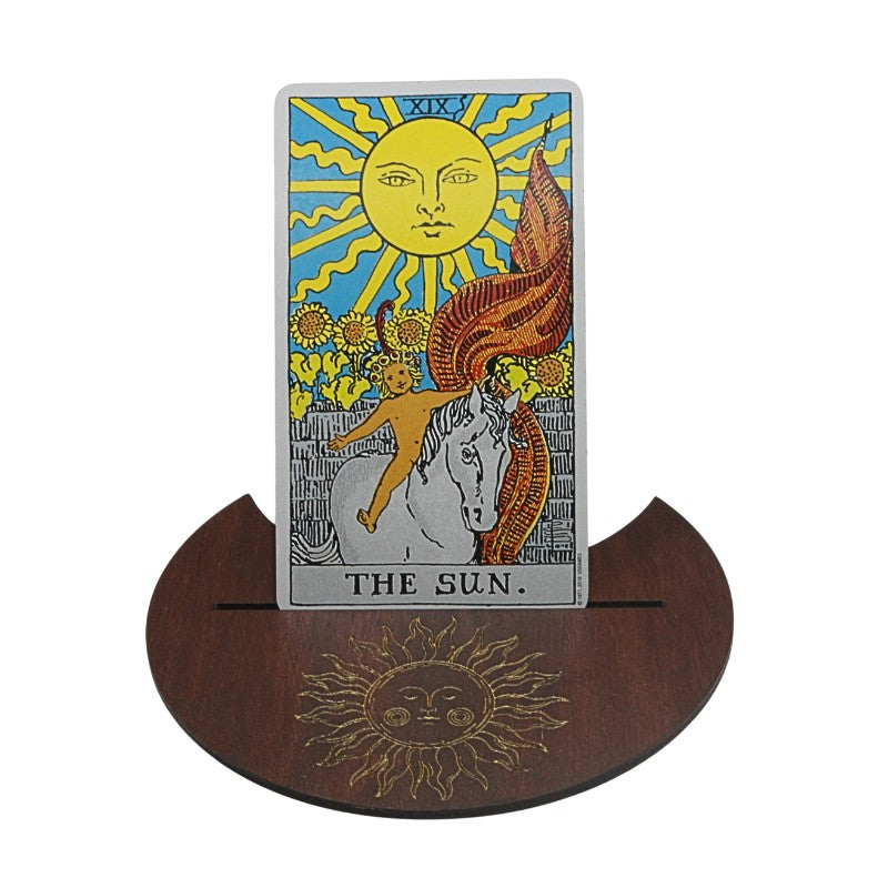 Tarot card titled 'The Sun' on a wooden stand with sun design.