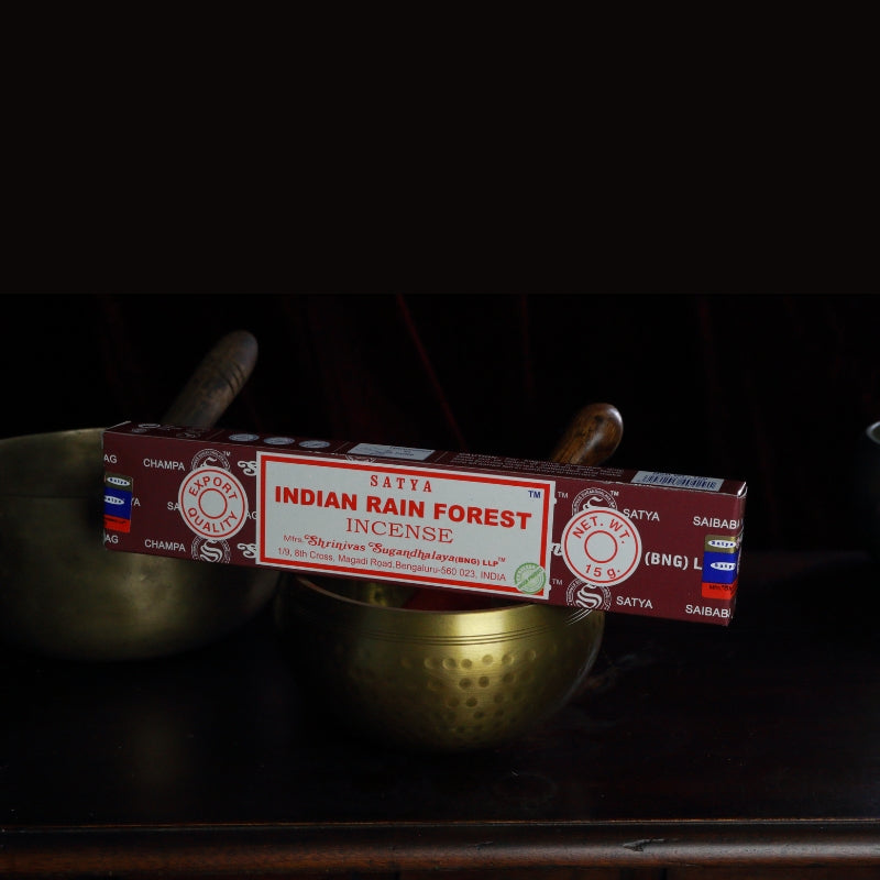 satya incense sticks sitting on a brass singing bowl