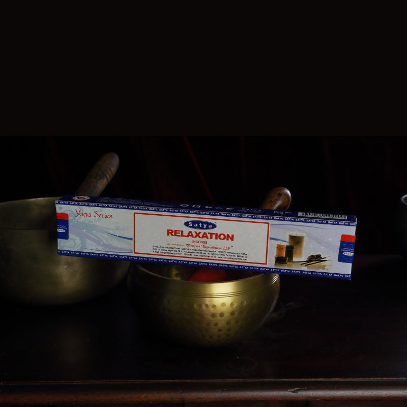 satya incense sticks sitting on a brass singing bowl