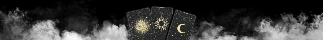 black background with white smoke wafting across. 3 black tarot cards in centre with the a gold sun & moon printed on them