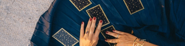 woman laying out tarot cards on a blue tarot cloth