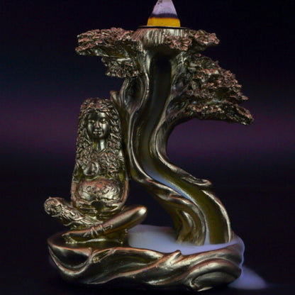 gold mother earth backflow incense cone burner with smoke billowing around it