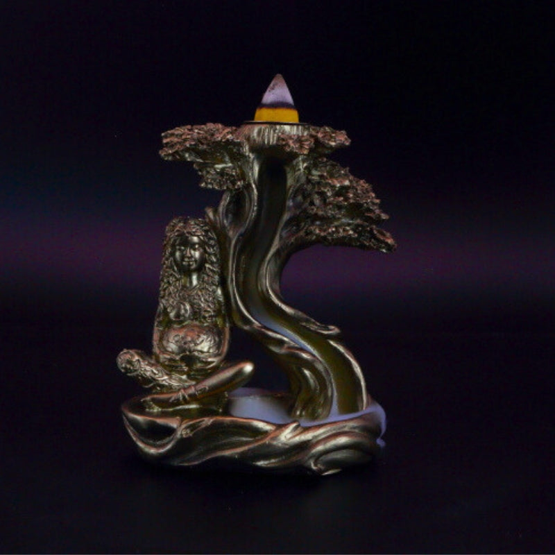 gold mother earth backflow incense cone burner with smoke billowing around it
