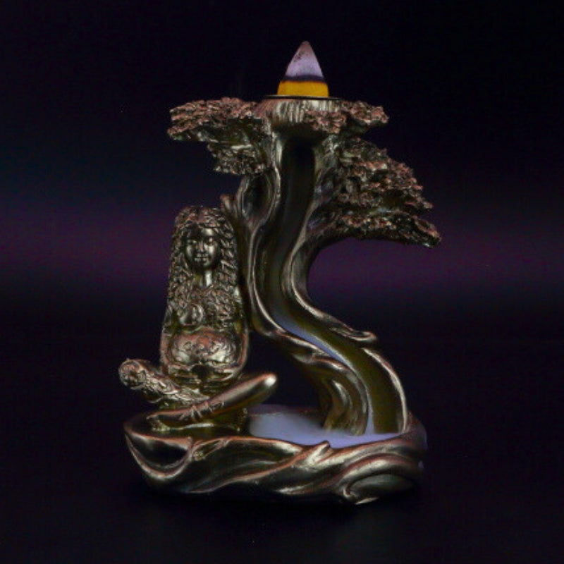 gold mother earth backflow incense cone burner with smoke billowing around it