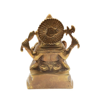 Gold-colored statue of a seated figure with a decorative headpiece on a white background