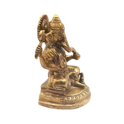 Bronze statue of a seated figure with intricate details on a white background