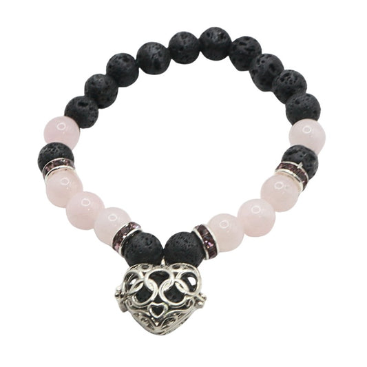 Bracelet with black and pink beads and a silver heart-shaped charm on a white background