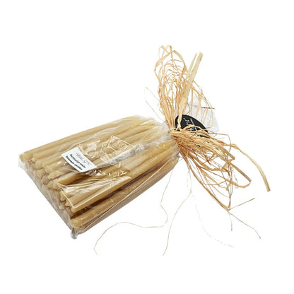 Packaged candles with decorative straw on a white background