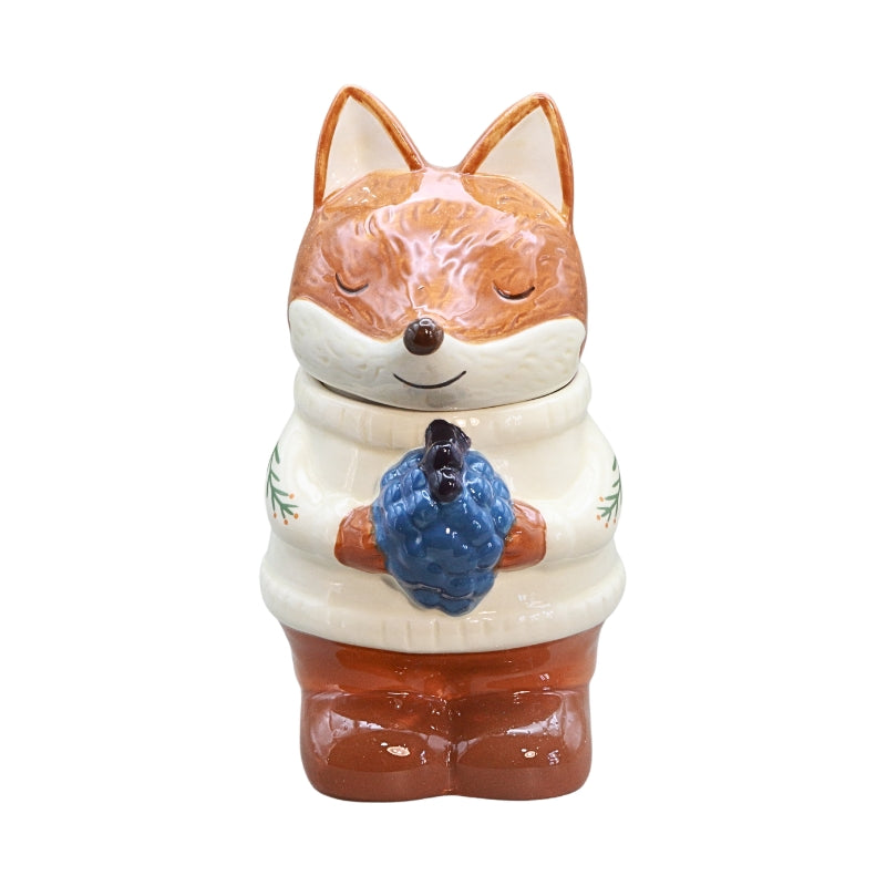 ceramic fox wearing a white jumper and holding blue berries, on a white background