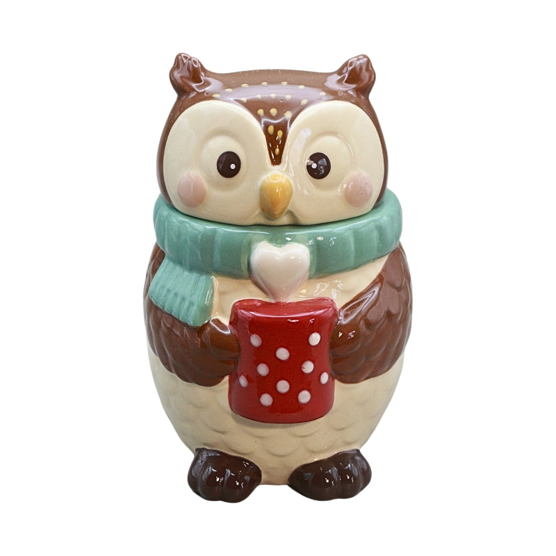 A ceramic owl figurine wearing a mint green scarf and holding a red mug with white polka dots, set against a plain white background.