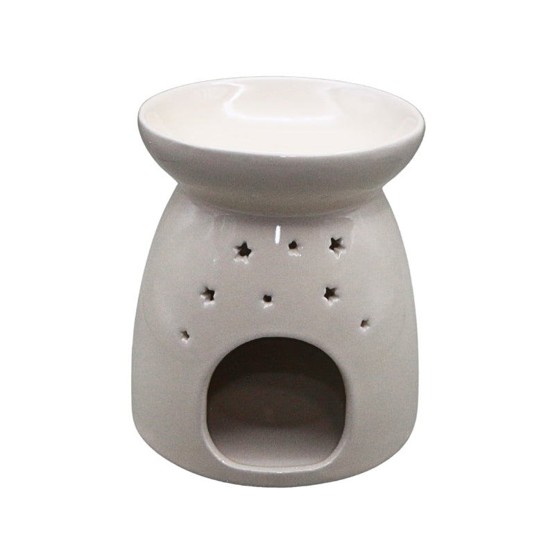 A white ceramic oil burner with star-shaped cutouts on the front, featuring a wide top dish and a lower opening for a candle, shown against a plain white background.