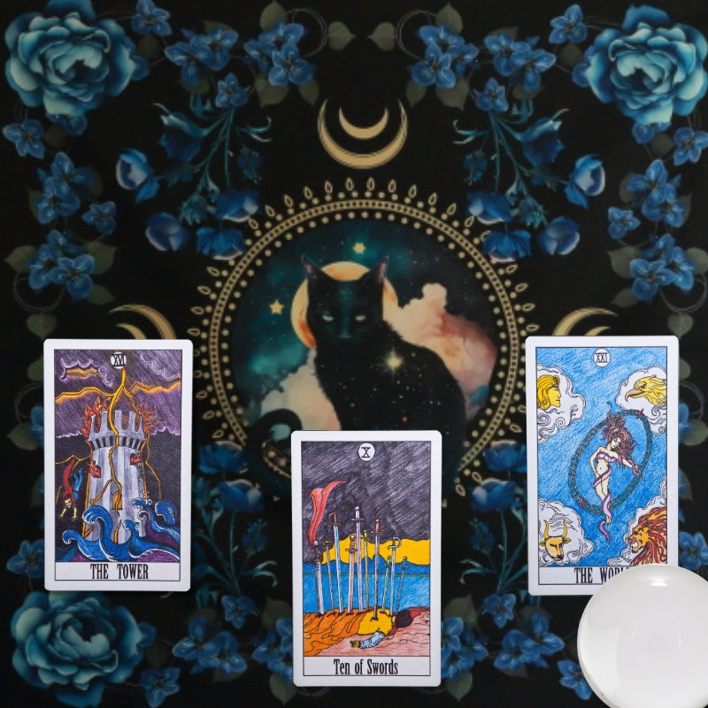 tarot cards and a crystal ball laid on top of a tarot cloth printed with a black cat on it