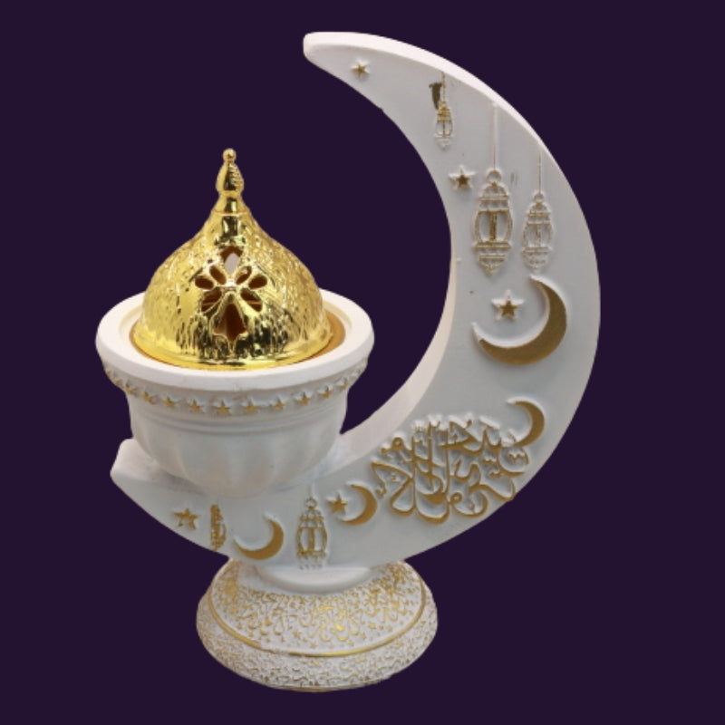 white and gold incense burner in the shape of a crescent moon