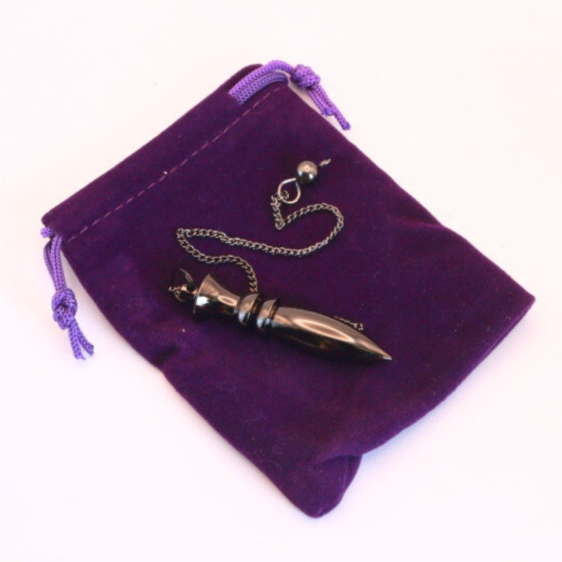 Brass pendulum on purple velvet pouch
