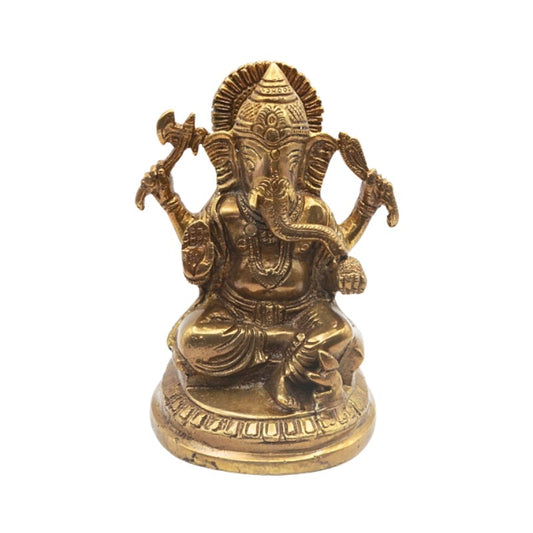 Brass statue of a seated deity with a white background