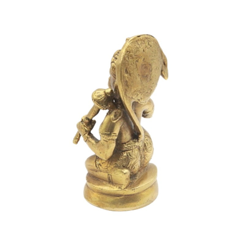 Gold-colored statue of a seated figure with a drum on a white background