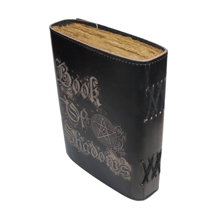 Leather bound book with gothic "book of shadows" written on the cover with a pentacle and brass coloured clasp with antiqued paper inside. The spine of the book has crossed leather across the sides
