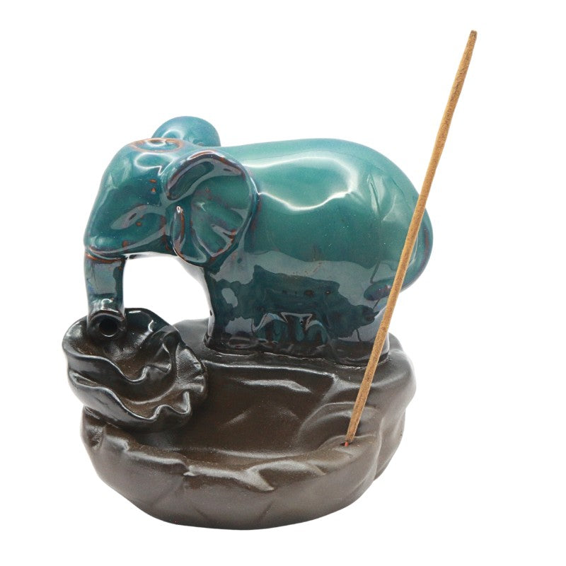 Teal ceramic elephant incense burner with a stick on a white background