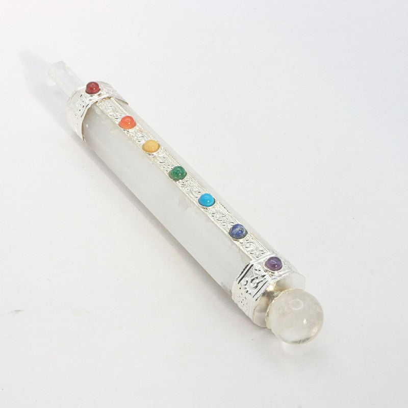 selenite crystal wand with chakra coloured stones on a white background