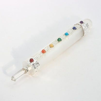 selenite crystal wand with chakra coloured stones on a white background