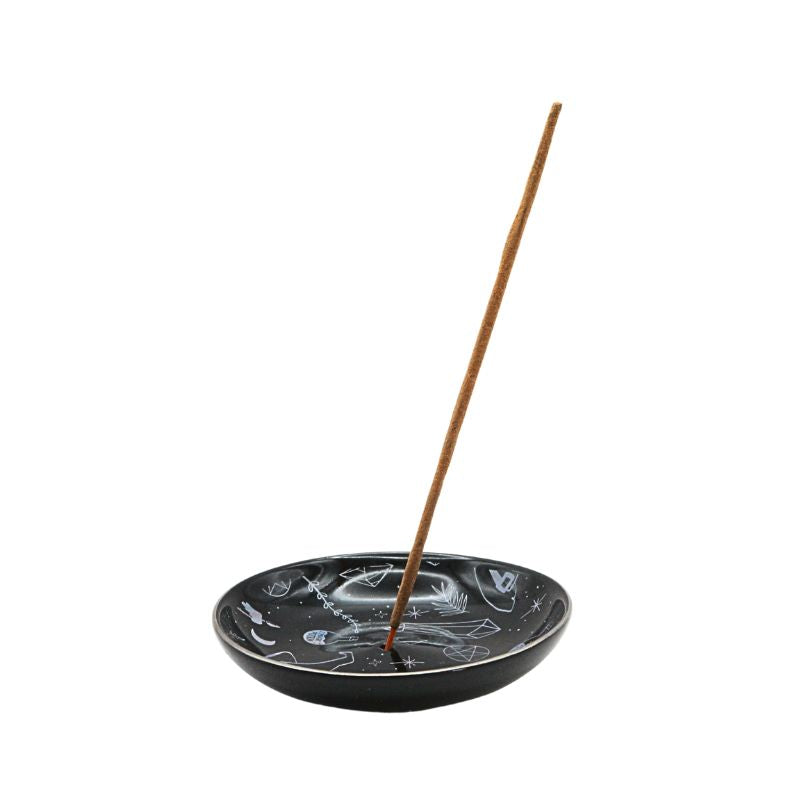 Black ceramic incense holder with a single incense stick on a white background