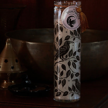 Glass bottle with decorative label featuring a bird design on a dark background