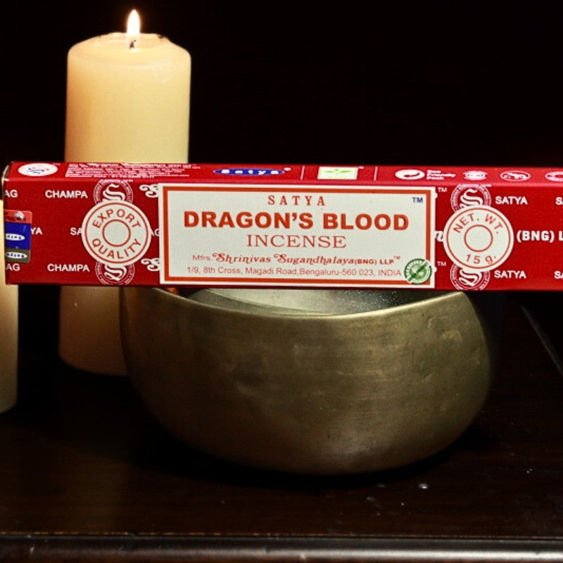 Dragon's blood incense on a brass singing bowl in front  of beeswax candles