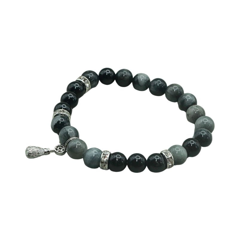 crystal bracelet with a silver coloured broom and pentacle charm, on a white background