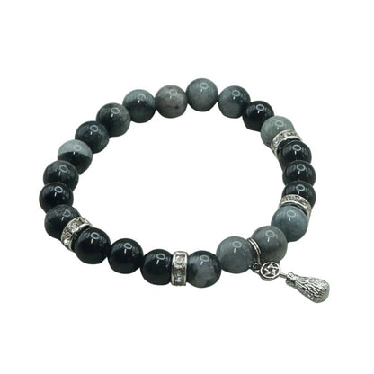 crystal bracelet with a silver coloured broom and pentacle charm, on a white background
