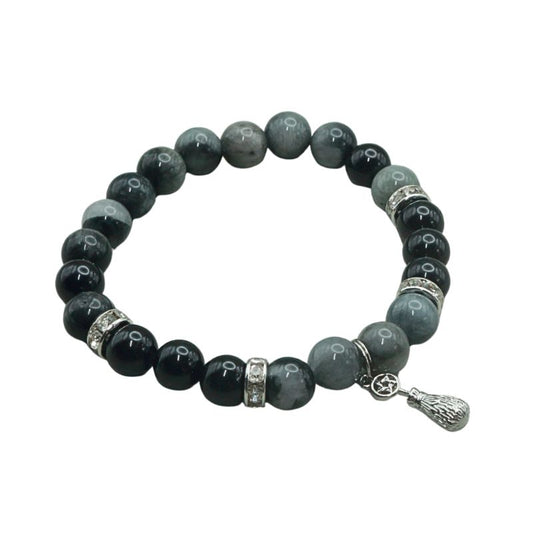 crystal bracelet with a silver coloured broom and pentacle charm, on a white background