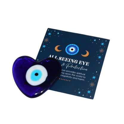 Blue heart-shaped evil eye amulet with a card explaining its meaning on a white background