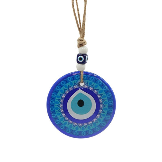 Blue evil eye pendant with a white bead on a white background