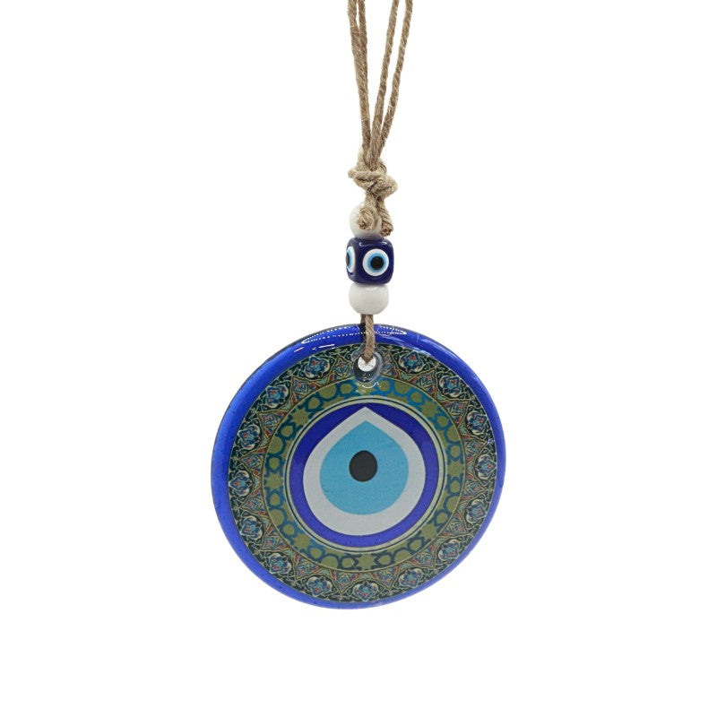 Blue evil eye pendant with green patterns on a white background