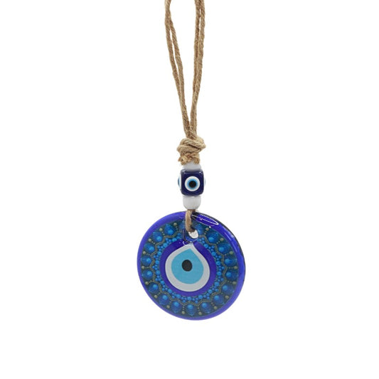 Blue evil eye pendant on a string against a white background