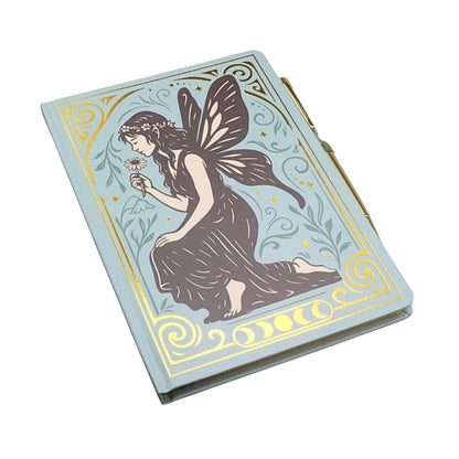 blue and gold notebook with a grey vintage style fairy on the cover, on a white background