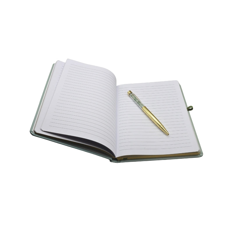 open lined book with gold edges, on a white background, with a gold and crystal chip pen sitting on top