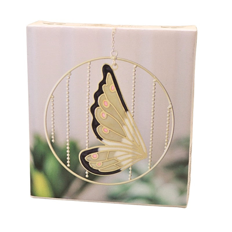 A gold butterfly-shaped suncatcher with black and pink accents, suspended inside a circular frame with bead strands, shown in front of its white packaging box.