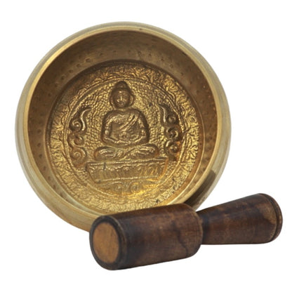 inside of flat bottomed singing bowl showing buddha carving and wooden striker