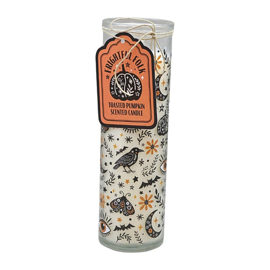 Glass tube candle with orange and black witchy designs on a white background