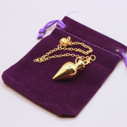 gold pendulum on purple velvet bag