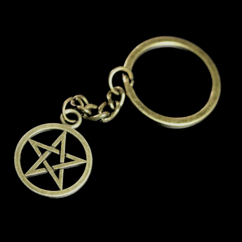 dark gold coloured key ring with a pentacle (5 pointed star within a circle) joined to a dark gold coloured ring by a dark gold coloured chain