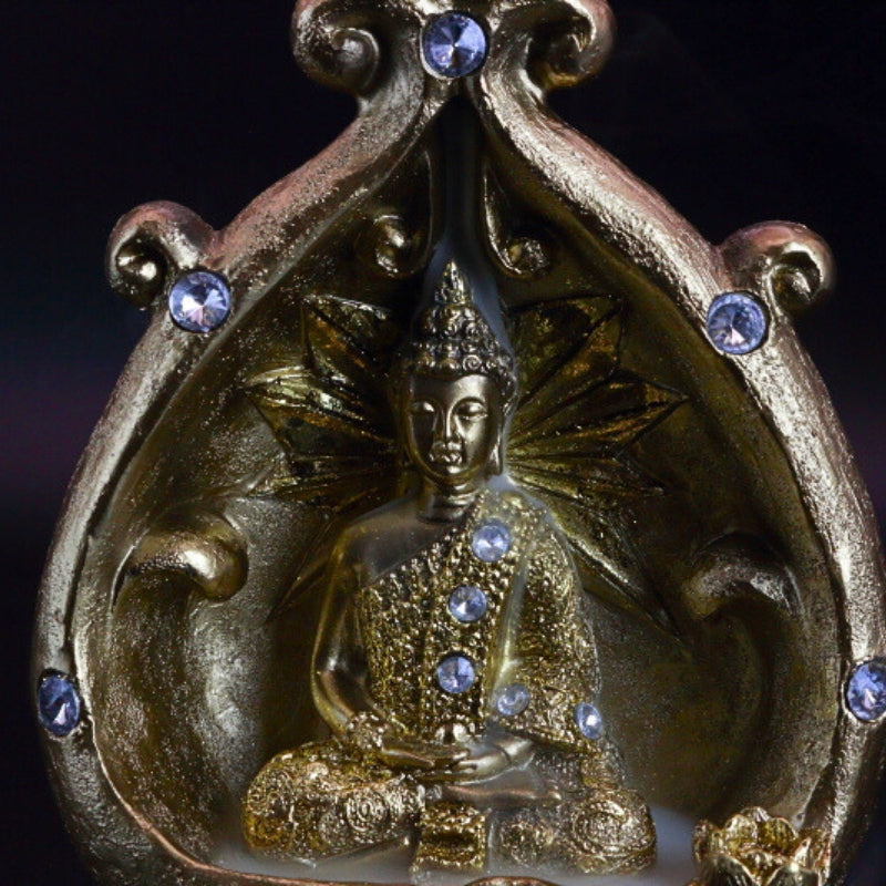 close up gold buddha backflow incense cone burner with smoke billowing around it