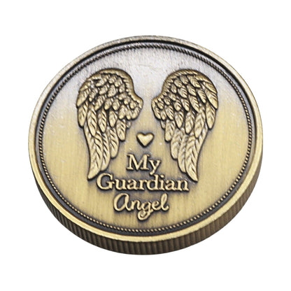 A round bronze-colored metal token or medallion featuring engraved angel wings, a small heart, and the words 'My Guardian Angel' on a plain white background.